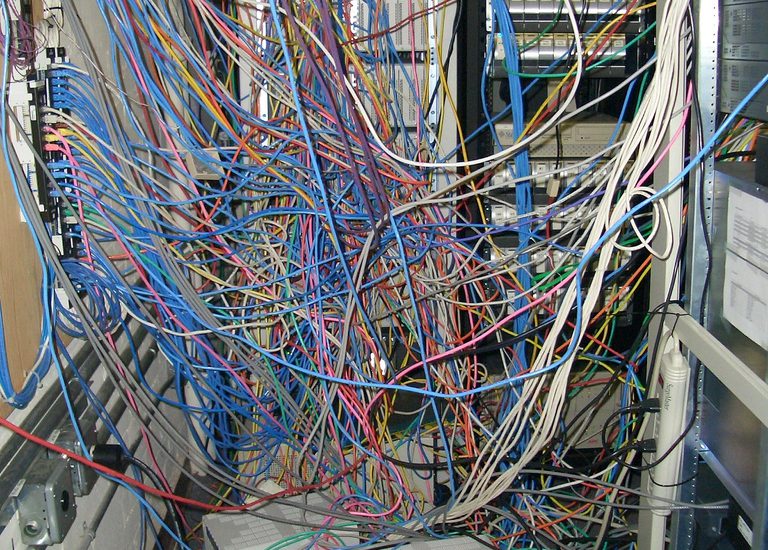 Hundreds of computer cables, all connected, but in a big tangled mess.