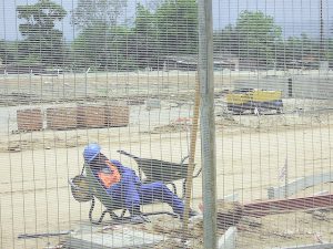 World Cup stadium construction worker sleeping on the job. Having coworkers who sleep or goof off is not good for company morale.