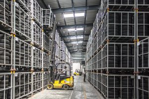 A forklift in a giant warehouse of tires in metal racks. Pictures like this make me shudder when I think of how companies have high inventory levels.