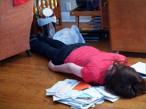 A woman lying face down on a pile of mail. It's nearly impossible to motivate others, and that shouldn't be our goal as leaders.
