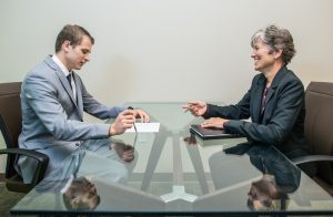 A young man on a job interview with a mature woman. If you recruit talent from your vendors, you should ask your vendors first, don't poach the talent directly.