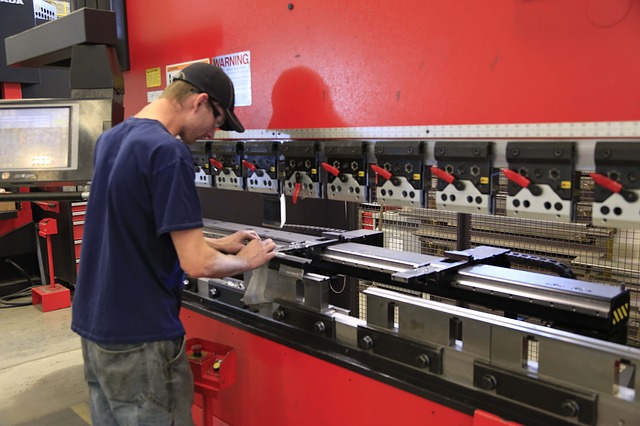 A metal worker working on a hydraulic press. If you cross-train your employees, you can avoid a worker shortage