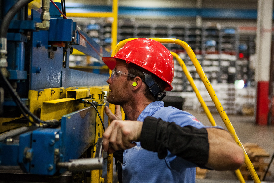 Photo of a factory worker wearing a red hard hat. This kind of safety equipment can prevent a safety lapse.