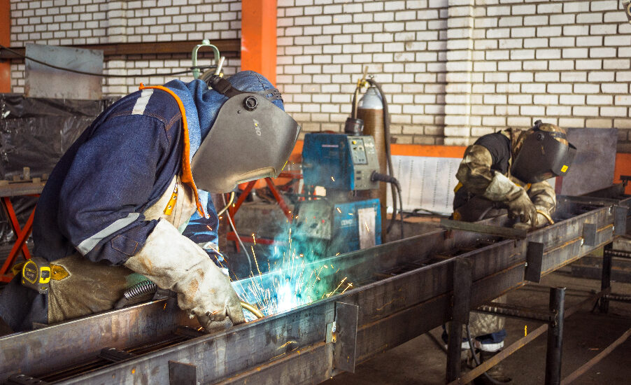 Photo of two men welding a piece of steel. Safety is everyone's responsibility, not just the managers'.