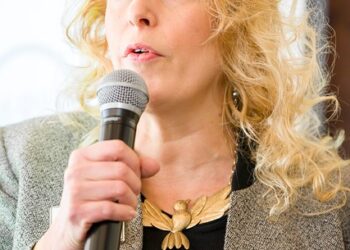 Photo of a woman giving a speech. This is one way to develop executive presence.