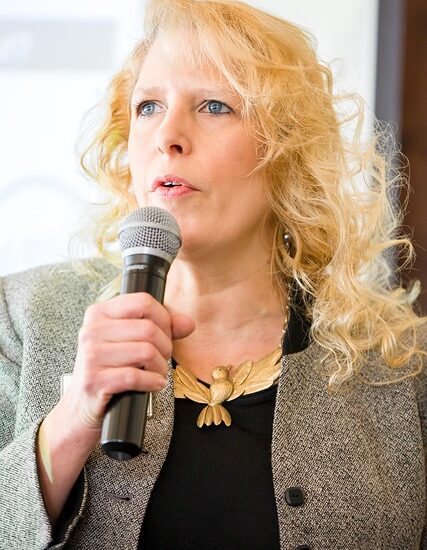 Photo of a woman giving a speech. This is one way to develop executive presence.