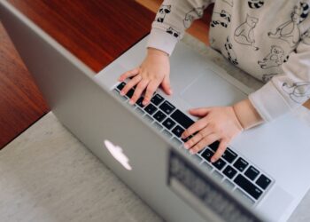 Photo of a baby's hands on a laptop. Represents multigenerational ownership.