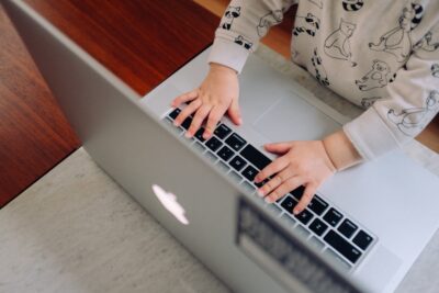 Photo of a baby's hands on a laptop. Represents multigenerational ownership.